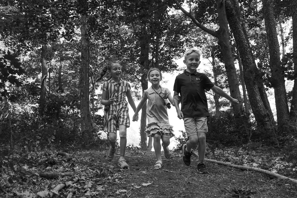black and white picture of kids running in woods