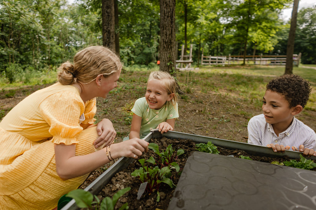 middle school student showing younger children plants