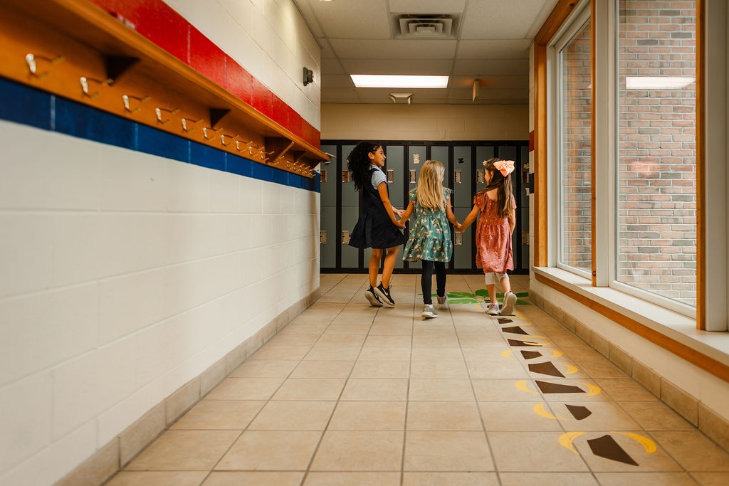 two girls skipping down the hallway